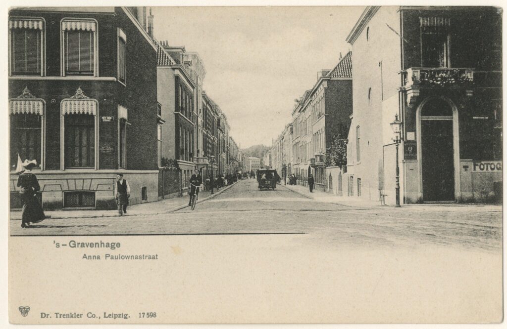 De voorstelling op een zwart-wit fotokaart is de Anna Paulownastraat in Den Haag te zien , met de huizen aan weerzijden, wandelaars op de stoep en voertuigen op de straat, onder andere een fietser. Er onder is ruimte om te schrijven.